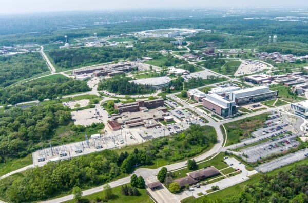 An aerial photo of Argonne National Laboratory, with several buildings connected by roads and surrounded by green trees.