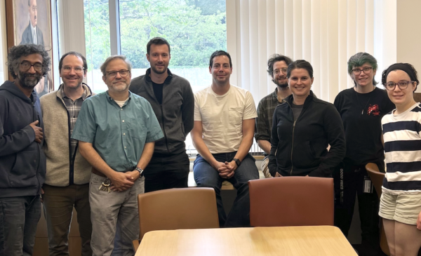 A group of men and women pose in a conference room.