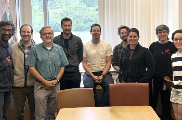 A group of men and women pose in a conference room.